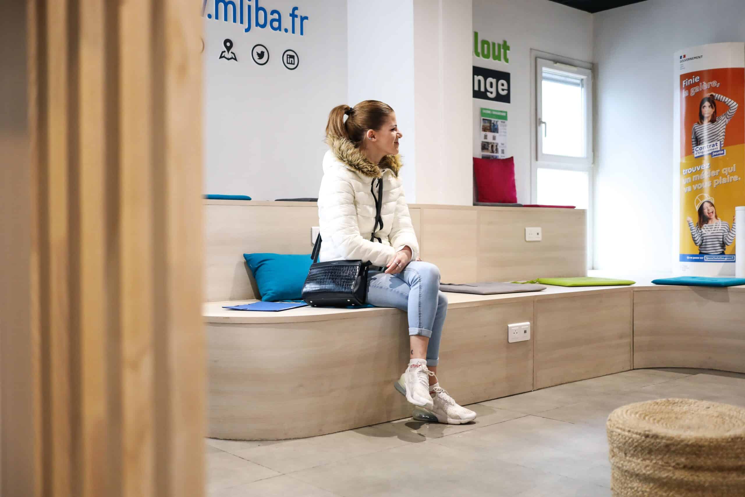 une jeune femme attend dans la salle d'attente de la mission locale