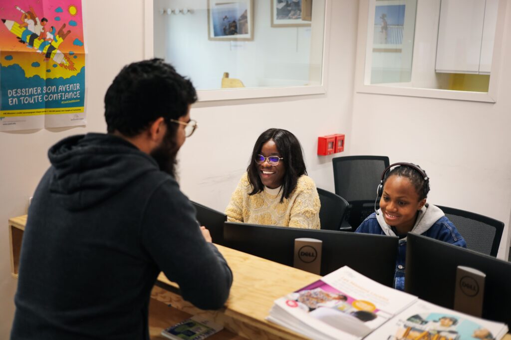 Un jeune est accueilli à l'accueil d'une mission locale, où un conseiller l'écoute avec attention et bienveillance.