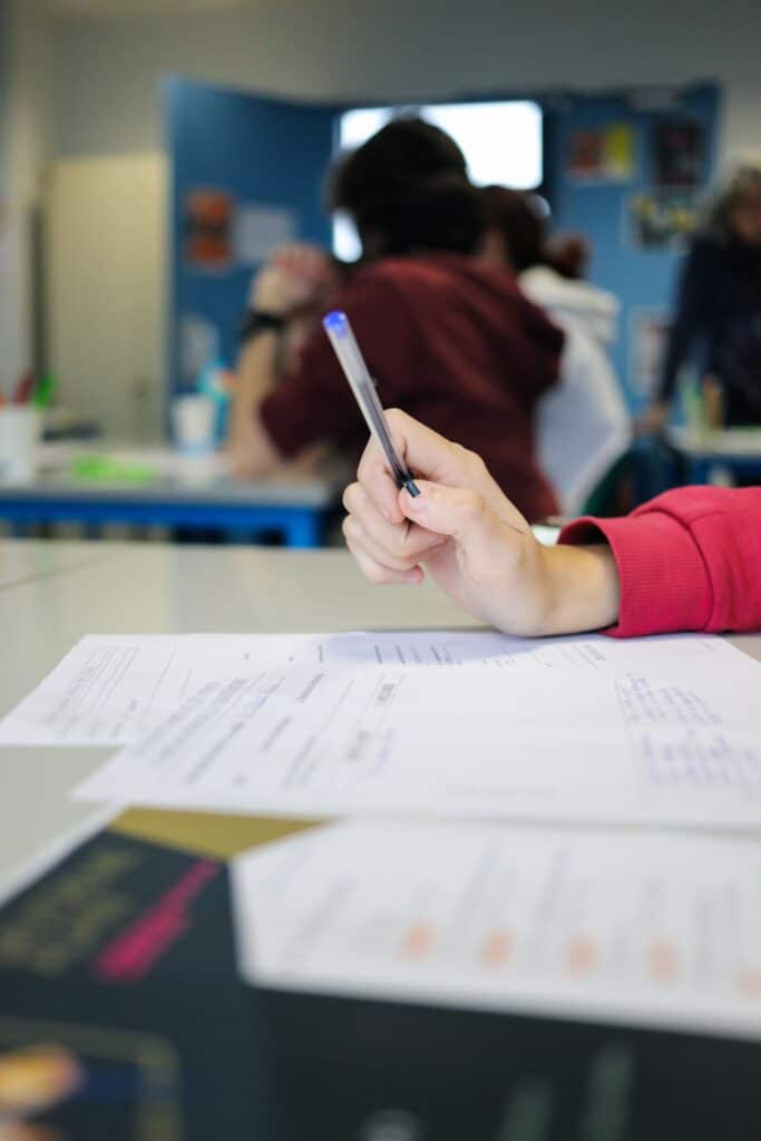 jeune qui écrit sa lettre de motivation pour une candidature à un emploi, accompagnée par la Mission Locale